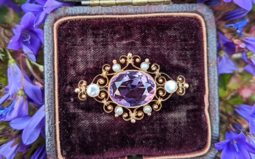 gold and silver round analog watch on black and purple case
